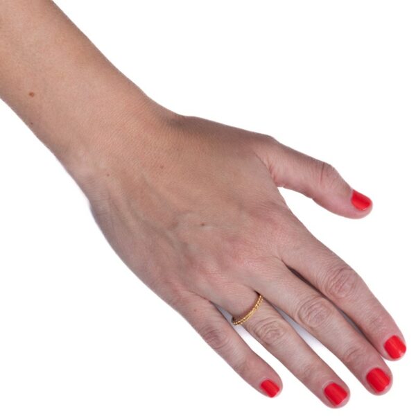 a woman's hand with red nails and a gold ring