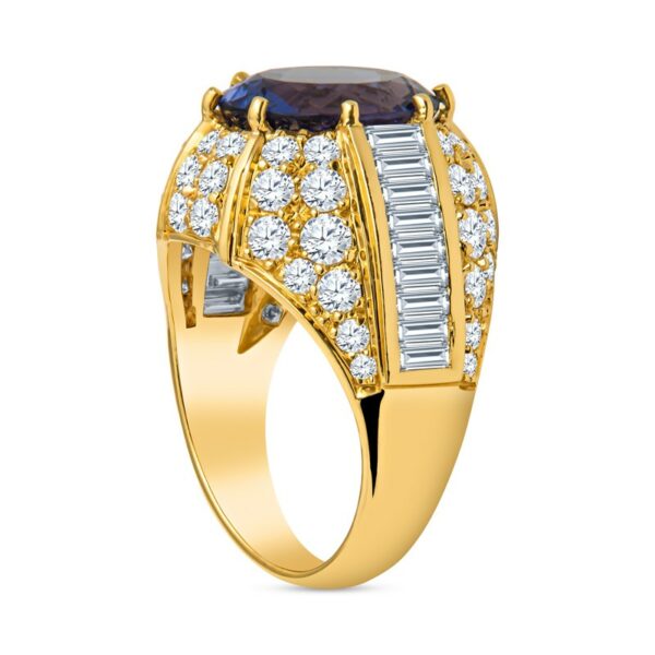 a gold ring with an oval shaped sapphire and baguettes