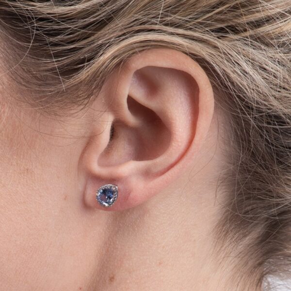 a close up of a person's ear with a blue stone