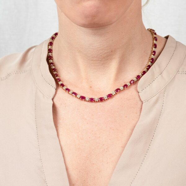 a woman wearing a necklace with red stones