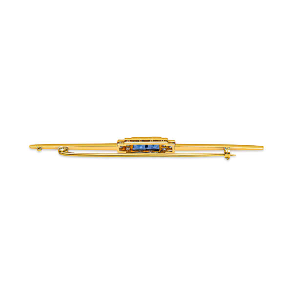 a gold hair clip with blue stones on it