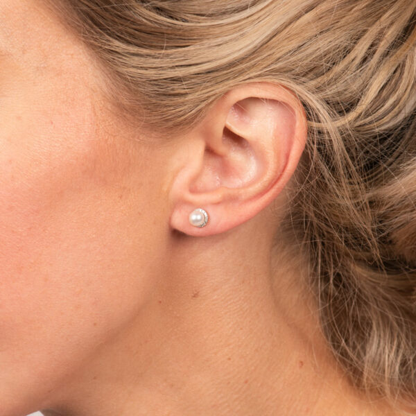 a woman wearing a pair of earrings on her ear