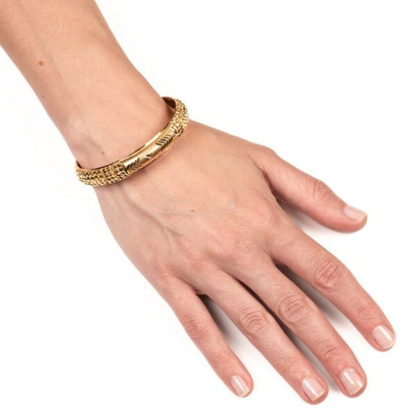 a woman's hand wearing a gold bracelet