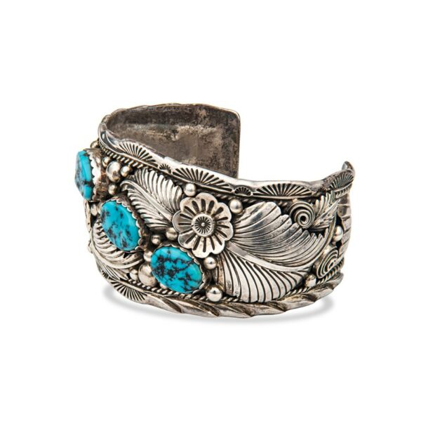 a silver bracelet with turquoise stones and flowers
