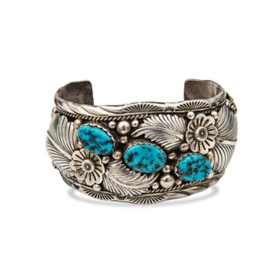a silver cuff with turquoise stones on it