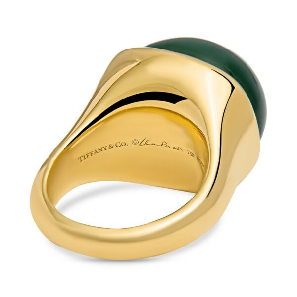 a gold ring with green onyxite in the center