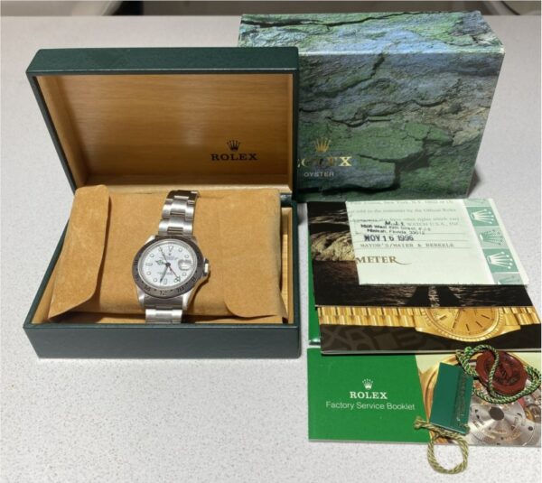 a rolex watch sitting in a box next to its packaging