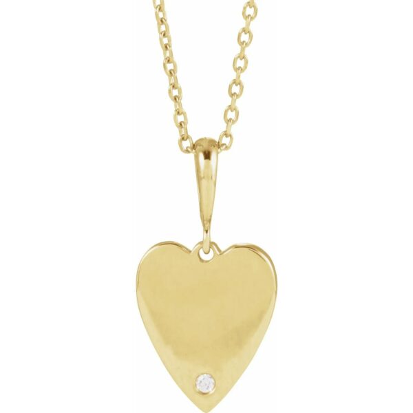 a gold heart pendant with a diamond
