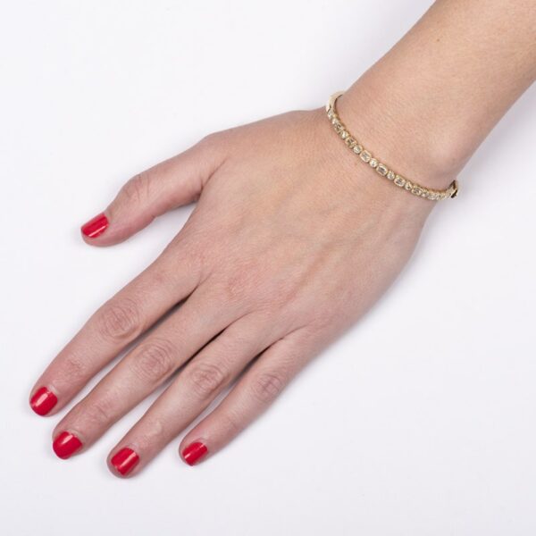 a woman's hand with red nails and a gold bracelet