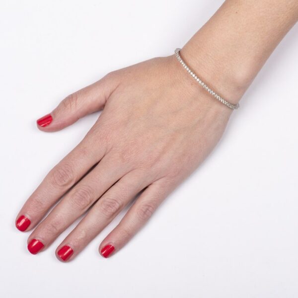 a woman's hand with red nails and a bracelet
