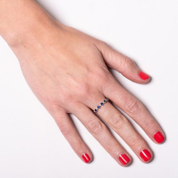a woman's hand with red nail polish and a ring