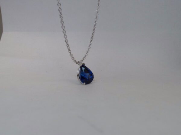 a necklace with a blue tear on it