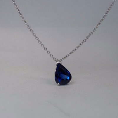 a blue tear shaped necklace on a chain