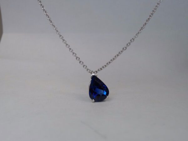 a blue tear shaped necklace on a chain