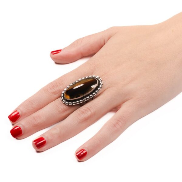 a woman's hand with red nail polish and a ring